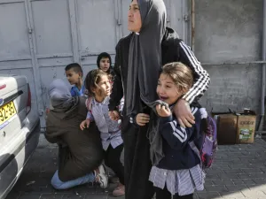 Women attempt to protect school children as they attempt to flee while stuck in clashes surrounding a demonstration demonstration by Israel's controversial separation barrier (AFP)