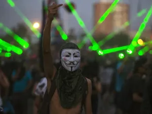 A demonstrator wearing Guy Fawkes mask gestures during a protest against the government, in Santiago on November 18, 2019. (AFP/ File Photo)