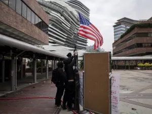 Protesters raise a US flag inside the Hong Kong Polytechnic University in the Hung Hom district of Hong Kong on November 20, 2019. A dwindling number of exhausted pro-democracy protesters barricaded inside the Hong Kong university defied warnings on November 19 to surrender, as a police siege of the campus stretched through a third day and China sent fresh signals that its patience with nearly six months of unrest was running out.