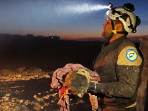 A member of the Syrian Civil Defense (White Helmets) carries a young victim following a reported Russian airstrike on the town of Maaret al-Numan in Syria's northwestern Idlib province on November 20, 2019. (AFP/ File Photo)