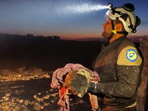 A member of the Syrian Civil Defense (White Helmets) carries a young victim following a reported Russian airstrike on the town of Maaret al-Numan in Syria's northwestern Idlib province on November 20, 2019. (AFP/ File Photo)