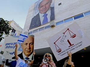 Supporters of Israeli Prime Minister Benjamin Netanyahu chant slogans and hold up signs in support of him during a counter-rally outside the Likud party headquaters in the coastal Mediterranean city of Tel Aviv on November 22, 2019. (AFP)