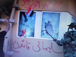 تظهر الصور مسلحين أمام الجدار بعد أن علقوا على نافذته علم "كتائب حزب الله"