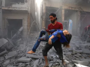 A man evacuates a young bombing casualty after a reported air strike by regime forces and their allies in the jihadist-held Syrian town of Maaret Al-Noman in the southern Idlib province, on May 26, 2019. (AFP/ File Photo)
