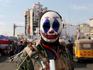 An Iraqi protester wearing the DC comic Joker character's mask poses for a picture during an anti-government demonstration in the capital Baghdad, on November 23, 2019. SABAH ARAR / AFP