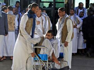 A Yemeni Huthi prisoner on a wheelchair is helped by others November 28, 2019, upon his arrival at the airport of the capital Sanaa, following his release, along with other prisoners, by the Saudi-led coalition. (AFP/ File Photo)