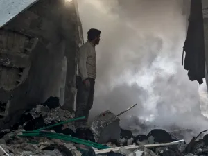 A man stands before a cloud of dust amidst rubble in a collapsed building following a reported air strike in the village of Balyun in Syria's northwestern Idlib province on December 7, 2019.  (AFP/ File Photo)