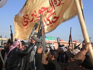 Armed members of Karbala clans lift their guns as they take to the streets to declare their support to the Iraqi armed forces to prohibit trouble makers from entering the southern Shiite shrine city on December 8, 2019. (AFP/ File Photo)