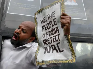 A protester shouts slogans from a bus after being taken into custody by police at the Town Hall during a demonstration held against India's new citizenship law in spite of a curfew in Bangalore (AFP)