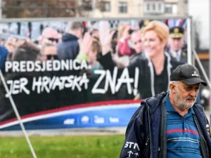 A man walks past a placard of the current Croatian President and candidate Kolinda Grabar-Kitarovic for the presidential election, from outside a window, in downtown Zagreb, December 21, 2019. Croatia voters will go to the polls on December 22, 2019 for the Croatian presidential election. Denis LOVROVIC / AFP