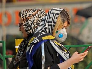 An Iranian woman walks with a mask to protect herself from air pollution on December 23, 2019 in the Iranian capital Tehran. Schools in Iran's Tehran province have been ordered shut until due to severe air pollution, authorities announced, extending their closure to a full week. Tehran city was cloaked by thick toxic smog for a third successive day on Monday that blanketed out landmarks like Milad Tower and the snow-capped Alborz mountains. ATTA KENARE / AFP