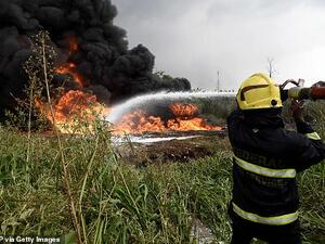 Federal firefighters try to put out fire from a ruptured oil pipeline at Peace Estate, Baruwa at Ipaja district of Lagos, Nigeria's commercial capital, on Thursday. (AFP)
