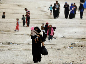 People walk through Ain Issa, one of the camps that holds displaced Syrians as well as foreign wives of ISIS fighters and their children. Thousands of foreign women and children languish in shelters in northeastern Syria, unwanted by their home governments and with no clear future. Delil Souleiman/AFP/Getty Images