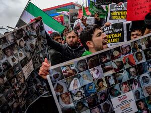 Protesters chant slogans and hold placards reading "More than 30.000 children killed by Russia and Assad regime" and bearing photographs of the victims during a protest against Syrian military operation in the rebel bastion of Idlib, northwestern Syria, taking place near the Russian Consulate, in Istanbul, on December 28, 2019. (AFP/ File Photo)