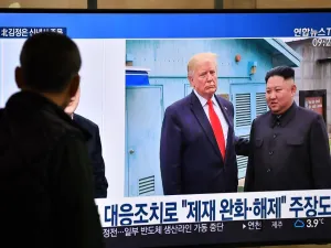 A man watches a television news programme showing file footage of a meeting between US President Donald Trump and North Korean leader Kim Jong Un at the truce village of Panmunjom, at a railway station in Seoul on January 1, 2020. North Korean leader Kim Jong Un has declared an end to its moratoriums on nuclear and intercontinental ballistic missile tests and threatened a demonstration of a "new strategic weapon" soon. Jung Yeon-je / AFP