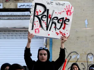 An Iranian mourner holds a placard during the final stage of funeral processions for slain top general Qasem Soleimani, in his hometown Kerman on January 7, 2020. (AFP/ File Photo)