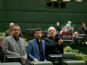 This handout picture provided by the Islamic Consultative Assembly News Agency (ICANA) shows an Iranian lawmaker holding a picture of slain top general Qasem Soleimani as he votes during a parliamentary session in Tehran.  (AFP/ File Photo)