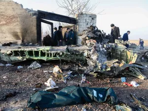 People stand near the wreckage after a Ukrainian plane carrying 176 passengers crashed near Imam Khomeini airport in Tehran on January 8, 2020. All 176 people on board a Ukrainian passenger plane were killed when it crashed shortly after taking off from Tehran on January 8, Iranian state media reported. State news agency IRNA said 167 passengers and nine crew members were on board the aircraft operated by Ukraine International Airlines. Rouhollah VAHDATI / ISNA / AFP