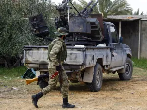 A fighter loyal to the internationally recognised Libyan Government of National Accord (GNA) walks past a vehicle in an area south of the Libyan capital Tripoli on January 12, 2020. (AFP/ File Photo)