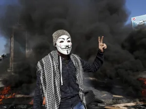 Lebanese anti-government protester flashes the victory sign in front of a burning roadblock during a demonstration in Beirut on January 14, 2020. (AFP/ File Photo)