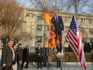 Members of the Basij, a militia loyal to the Islamic republic's establishment, burn a cardboard cutout of Britain's ambassador Rob Macaire along a Union Jack and US flag during a memorial for victims of the Ukraine plane crash, at University of Tehran on January 14, 2020. Iran signalled it could expel Britain's ambassador in case of further "interference" in its affairs after a row over a vigil he attended for those killed in last week's downing of a Ukrainian plane. ATTA KENARE / AFP