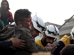 Members of the Syrian Civil Defence, also known as the White Helmets, recover a wounded boy from the rubble of a building following a regime air strike on a vegetable market in Syria's last major opposition bastion of Idlib on January 15, 2020. (AFP/ File Photo)