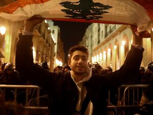 A Lebanese protester waves a national flag during an anti-government demonstration near the parliament in Beirut's downtown district on January 16, 2019. Lebanon's security forces released most of the 100 plus anti-government protesters detained in the past 48 hours, lawyers told AFP, after two nights of violent demonstrations in Beirut. PATRICK BAZ / AFP