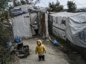 A child stands at a makeshift camp next to the refugee camp of Moria, in the island of Lesbos on January 21, 2020. Greece's conservative government reinstated the migration ministry six months after scrapping it, amid frantic efforts to relocate thousands of asylum seekers from dismal island camps. ARIS MESSINIS / AFP
