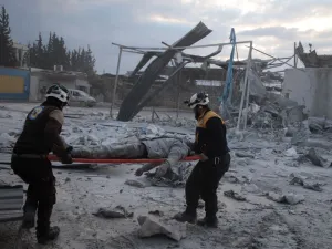 Members of the Syrian Civil Defence, also known as the White Helmets, load a body onto a stretcher following a reported airstrike on the village of Kafr Naha, in the western countryside of the northern province of Aleppo, on January 21, 2020. (AFP/ File Photo)