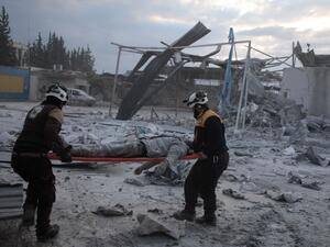Members of the Syrian Civil Defence, also known as the White Helmets, load a body onto a stretcher following a reported airstrike on the village of Kafr Naha, in the western countryside of the northern province of Aleppo, on January 21, 2020. (AFP/ File Photo)