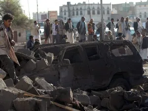 Yemenis stand at the site of a Saudi airstrike against Houthi rebels near Sanaa Airport on March 26, 2015, which killed at least 13 people. (photo credit: AFP/Mohammed Huwais)
