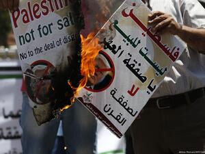 Palestinians protest against Trump's deal of the century in the West Bank city of Ramallah on 2 July 2018 [Abbas Momani/AFP/Getty Images]