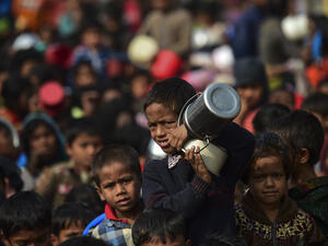 A Rohingya Muslim refugee waits with others for food aid at Thankhali refugee camp in Bangladesh's Ukhia district on January 12, 2018. (AFP Photo/Munir Uz Zaman)