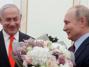 Russian President Vladimir Putin holds flowers next to Israeli Prime Minister Benjamin Netanyahu as they meet at the Kremlin in Moscow on January 30, 2020. MAXIM SHEMETOV / POOL / AFP