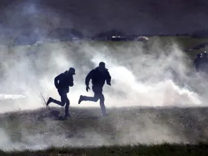 Palestinian protesters run for cover amid clashes with Israeli troops during a demonstration against a US brokered Middle East peace plan, near the West Bank village of Tamun near the Jordan Valley on January 31, 2020. AFP