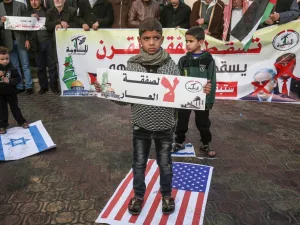 A Palestinian demonstrator takes part in a protest against a US-brokered Middle East peace plan, while holding placard that reads in Arabic "No to the deal of shame", in Rafah in the southern Gaza Strip, on February 1, 2020. SAID KHATIB / AFP