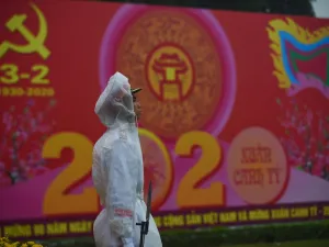 A policeman stands in front of a poster marking the 90th anniversary of the Communist Party of Vietnam in Hanoi on February 3, 2020. Vietnam suspends mainland China flights over virus fears as it spread to two dozen nations and killed 259 people in China where it originated in the city of Wuhan. Nhac NGUYEN / AFP
