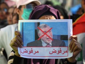 An Iraqi woman lifts a picture of the premier-designate Mohammad Allawi with the inscription "rejected", during an anti-government demonstration in the capital Baghdad's Tahrir square, on February 4, 2020. Anti-government demonstrators faced off against followers of the influential cleric Moqtada Sadr in protest squares across Iraq, a day after one demonstrator was killed in a clash between the two sides. Sadr backed the anti-government rallies when they erupted in October but has split with them by endorsi