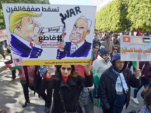Arabic writing on placards reads: "Jerusalem is the capital of Palestine" (R) and "Down with the 'Deal of the Century', #Boycott" next to cartoon images of Trump and Israel's Prime Minister Benjamin Netanyahu. FETHI BELAID / AFP