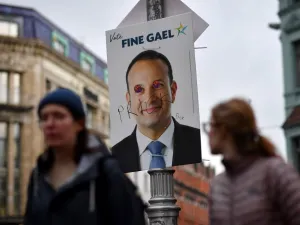 Pedestrians walk past a defaced campaign poster featuring Ireland's Prime Minister and leader of the Fine Gael party, Leo Varadkar as they walk along a street in Dublin on February 7, 2020, on the eve of the country's General Election. Ireland on Friday entered the final day of campaigning before this weekend's election, as polls predicted a historic three-way fight for control of the next government. Prime Minister Leo Varadkar, of the Fine Gael party, was canvassing in the western town of Ennis while Fian