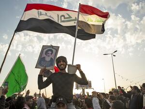 An Iraqi demonstrator carries a portrait of Grand Ayatollah Ali Sistani during an anti-government demonstration in the southern city of Basra on February 7, 2020. AFP/ File