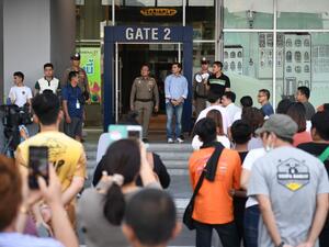 People gather outside the Terminal 21 shopping mall as they seek information on picking up vehicles and other belongings left during a mass shooting at the complex in Nakhon Ratchasima on February 9, 2020.  AFP