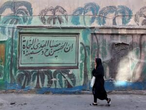 An Iranian woman walks past a mural in the southern Tehran district of Molavi on February 9, 2020. In a country weighed down by sanctions, shaken by protests and stressed by military tensions with the United States, many Tehranis struggle to hide their pessimism. ATTA KENARE / AFP
