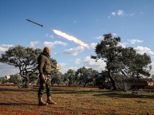 A Syrian rebel fighter remotely-fires a rocket from a truck-mounted launcher at a position in the countryside of Idlib towards regime forces positions in the southern countryside of Syria's Aleppo province on February 10, 2020. Omar HAJ KADOUR / AFP