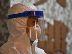 A medical personnel looks on as he stands in the ground of a residential estate, in Hong Kong, early on February 11, 2020, after two people in the block were confirmed to have contracted the coronavirus according to local newspaper reports. Anthony WALLACE / AFP
