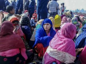 Rohingya refugees wait in an area following a boat capsizing accident, in Teknaf on February 11, 2020. At least 14 people drowned and dozens more were unaccounted for after a boat carrying Rohingya refugees sank off southern Bangladesh early February 11, officials said. STR / AFP