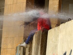 A Lebanese Protester is hit with a burst from a water cannon during clashes with army soldiers on February 11, 2020, as demonstrators gather in the heart of Beirut to stop a confidence vote for a new government, which they say fails to address their demands and cannot rescue the ailing country. Security forces used tear gas and water cannon to break up groups of demonstrators who hurled rocks over the blast walls erected around parliament. The Red Cross reported 24 people had been hospitalised and 147 treat
