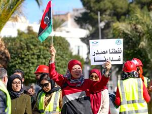 Libyans carry placards as they gather in front of the National Oil Corporation to protest against a blockade launched by groups allied to military strongman Khalifa Haftar last month of eastern Libya's main oil terminals, In the Libyan capital Tripoli on February 12, 2020. Mahmud TURKIA / AFP