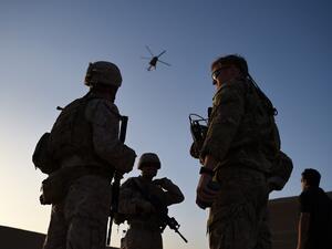 In this file photo taken on August 27, 2017 US Marines and Afghan Commandos stand together as an Afghan Air Force helicopter flies past during a combat training exercise at Shorab Military Camp in Lashkar Gah in Helmand province. The United States has secured a seven-day reduction in violence in talks to help seek a negotiated settlement in Afghanistan, Pentagon chief Mark Esper said February 13, 2020. The announcement came as NATO defence ministers met in Brussels and a day after Afghan President Ashraf Gh