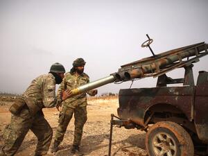 Turkish-backed Syrian fighters load a make-shift rocket launcher mounted on the back of a pickup truck in the village of Miznaz, on the western outskirts of Aleppo province, on February 14, 2020 as they prepare for a counter-offensive against advancing government forces in the Aleppo countryside. AAREF WATAD / AFP